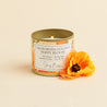 California golden poppy scented soy candle in a brushed gold tin with a wooden wick.